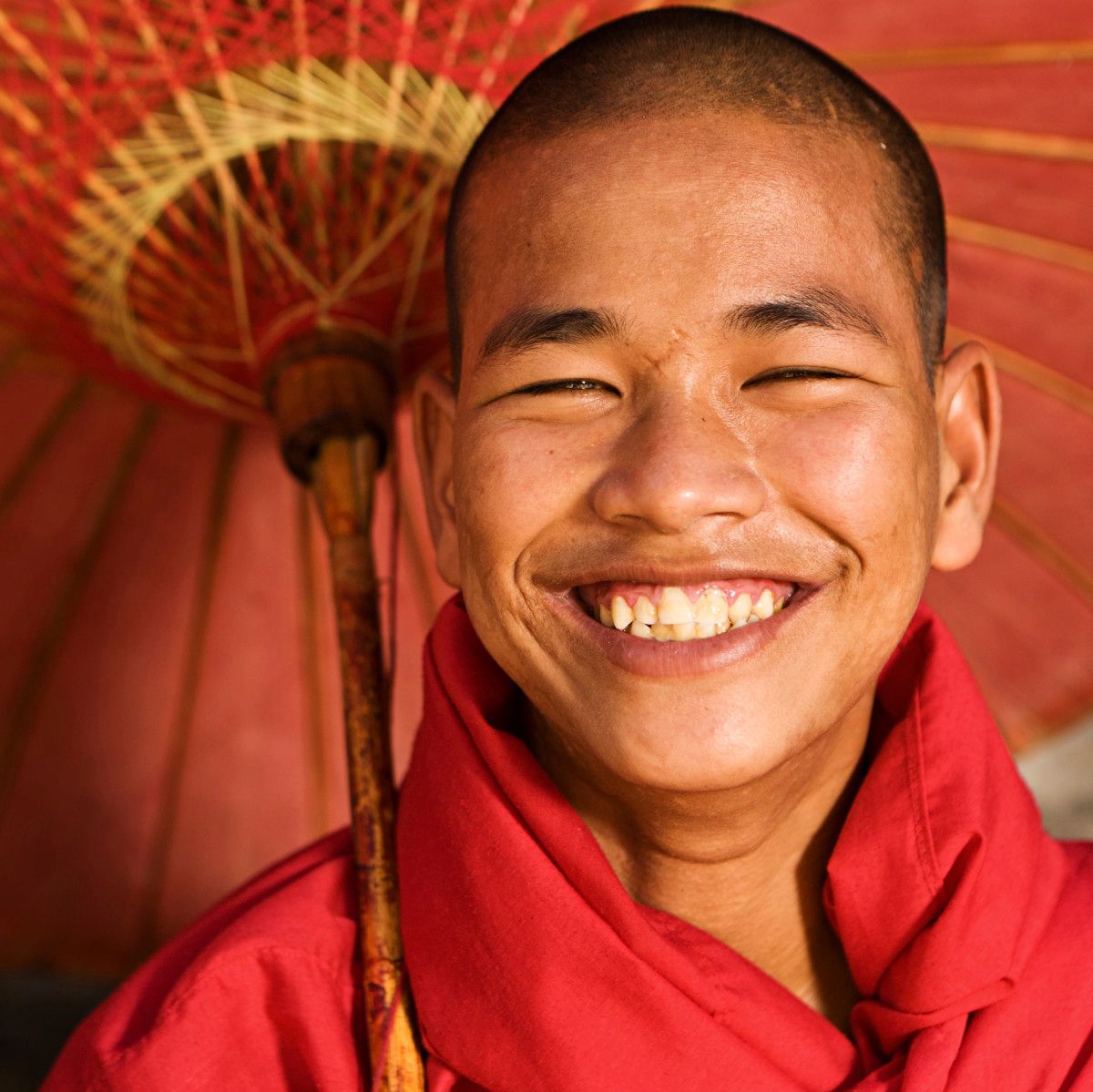 Man smiling under a tropical umbrella
