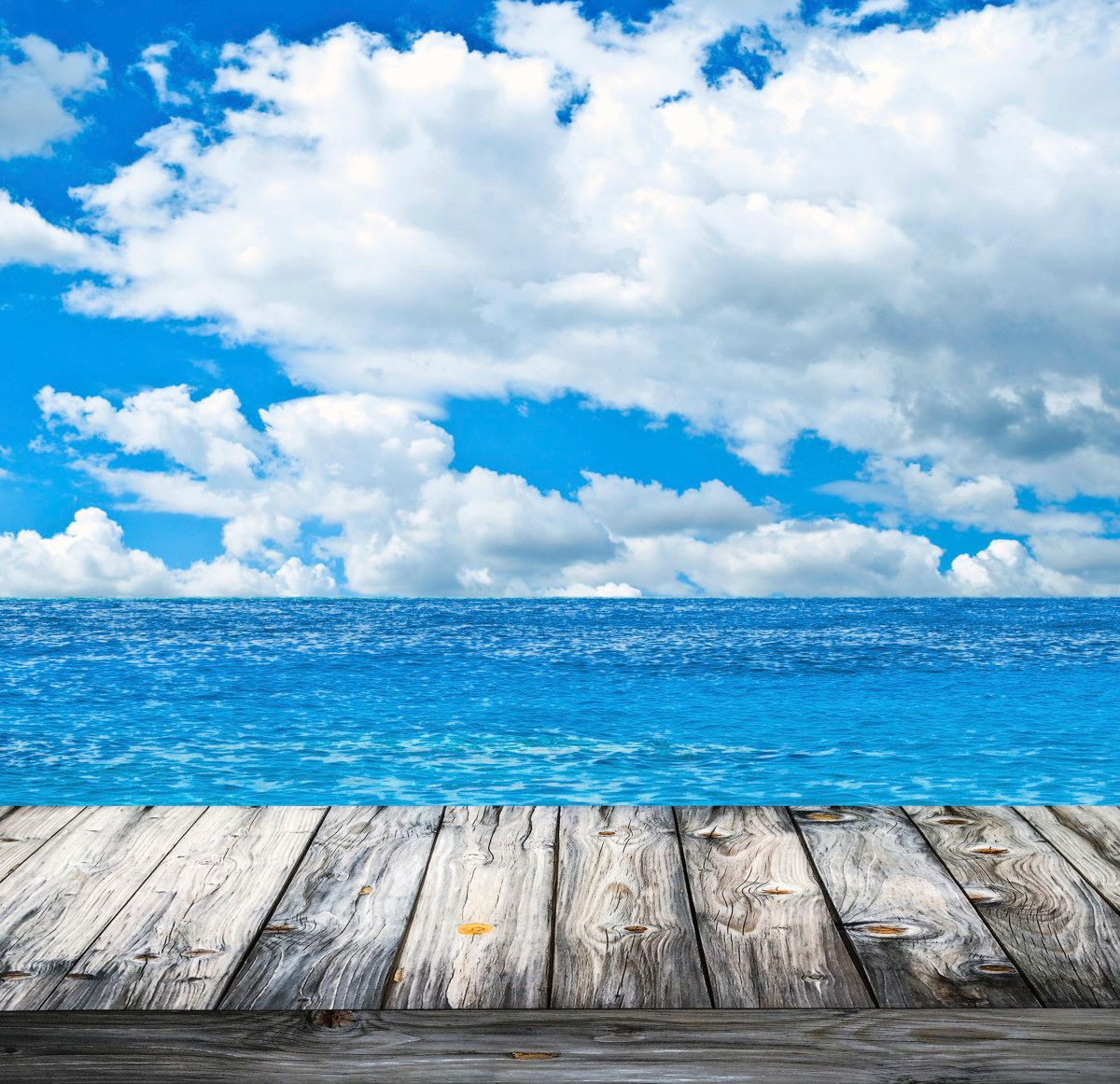 Looking at the clouds over the ocean from a wooden pier.
