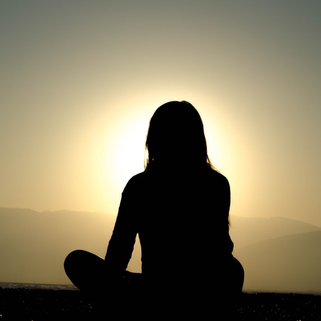 image of a woman sitting and meditating